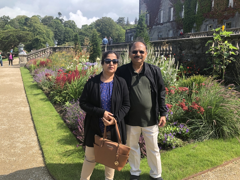 Deux personnes posant dans un jardin avec des fleurs.