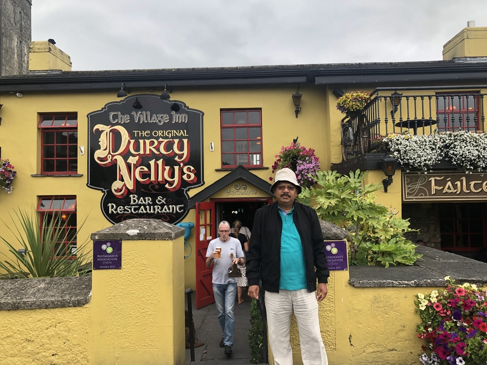 Homme debout dehors à l'entrée d'un restaurant.