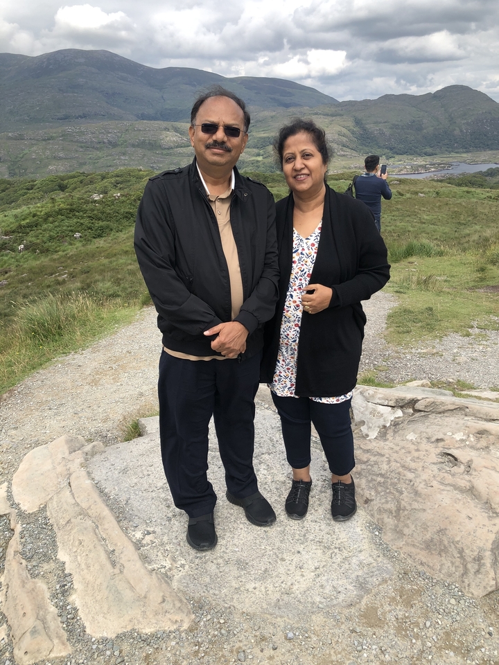 Deux personnes debout à l'extérieur sur un sentier vallonné.