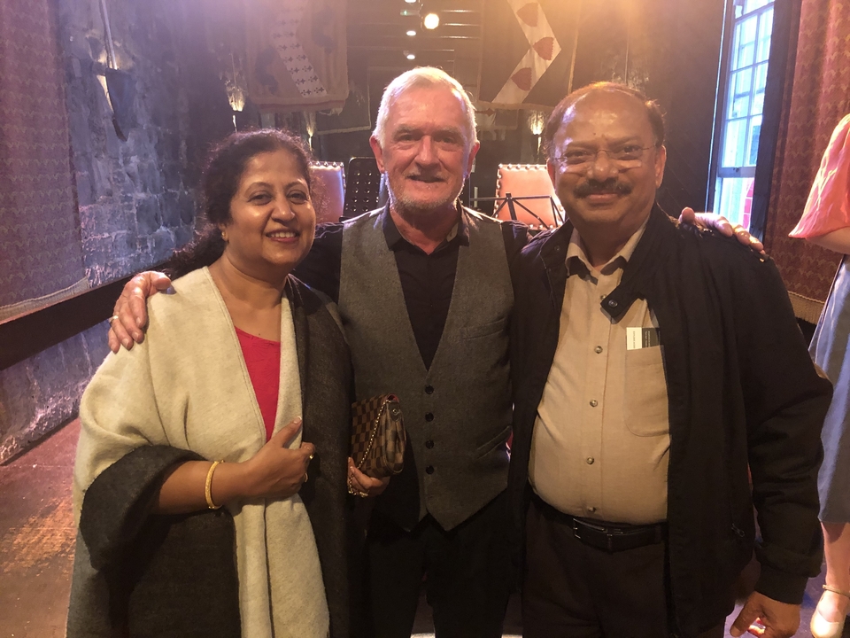 Trois personnes posant ensemble à l'intérieur.