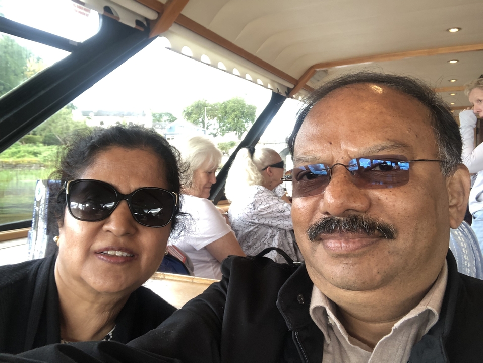 Deux personnes posant sur un bateau avec d'autres en arrière-plan.