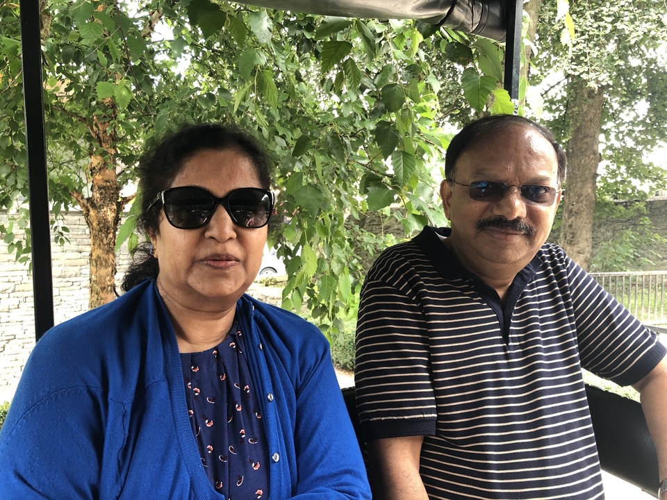 Deux personnes assises sous un banc d'arbre.
Note: The phrase "tree bench" is a bit ambiguous in English. If you meant "a bench under a tree," it would be: "Deux personnes assises sur un banc sous un arbre."