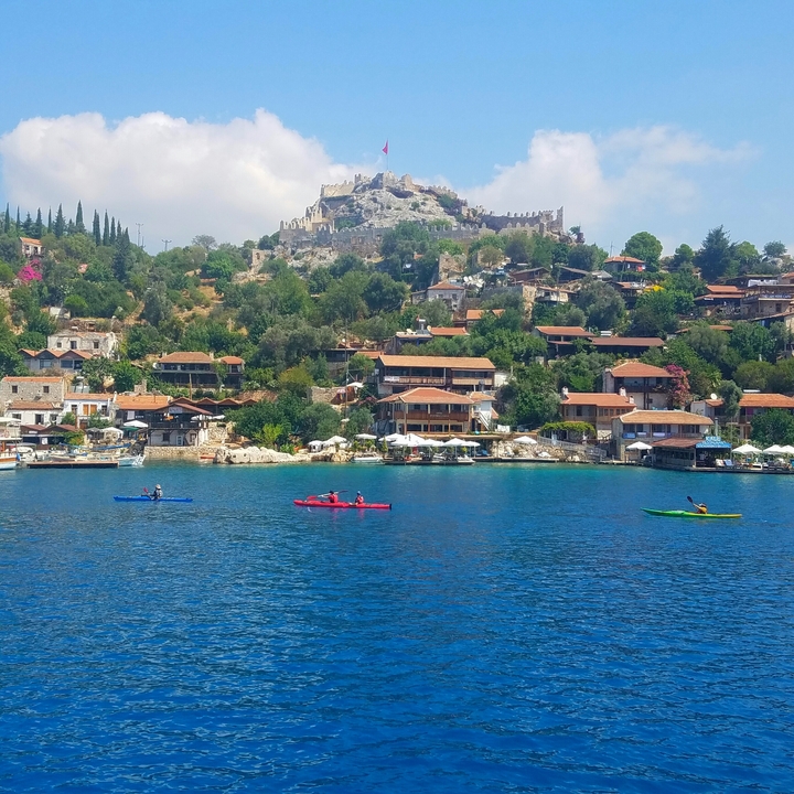 Village côtier avec des gens faisant du kayak sur la mer.