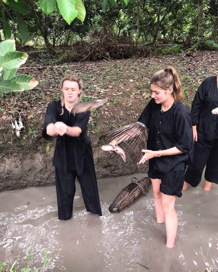 Dos mujeres participando en una actividad de pesca, pescando con equipo tradicional.