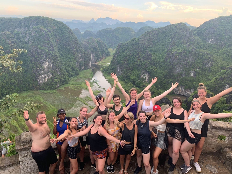 Grupo de personas posando con una vista panorámica de un valle fluvial.
