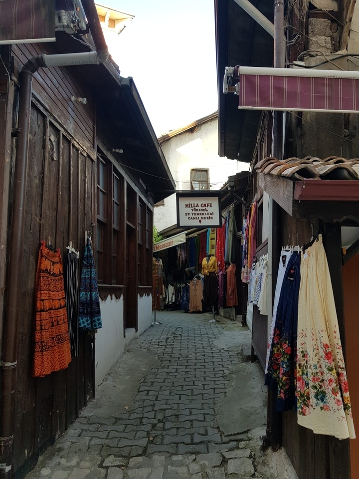 Rue étroite bordée de magasins et de vêtements.