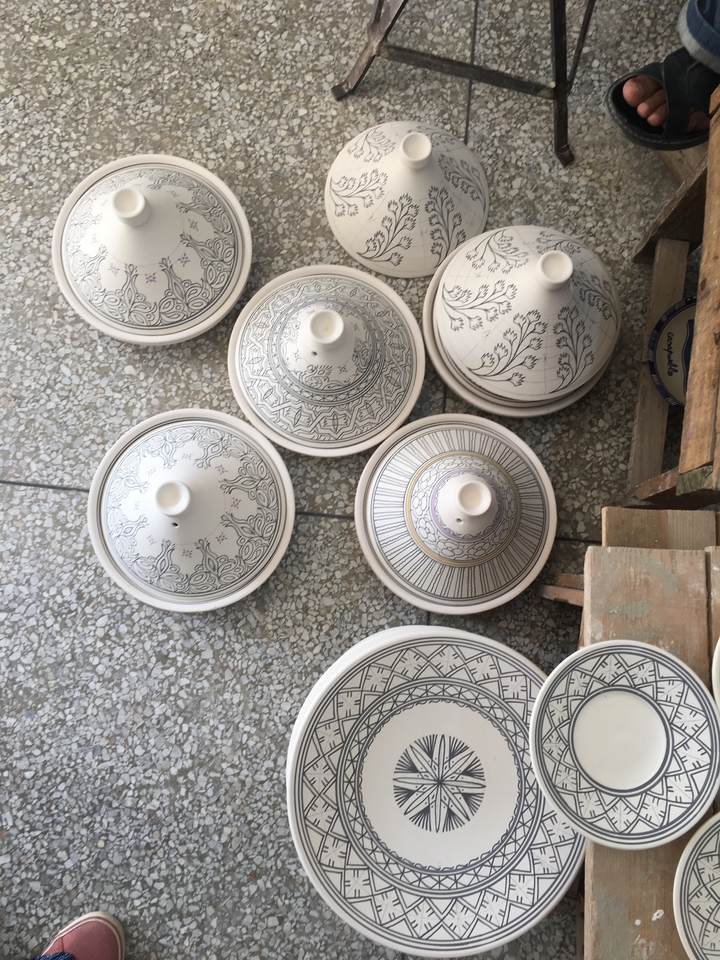 Tajines décoratifs sur un sol carrelé.