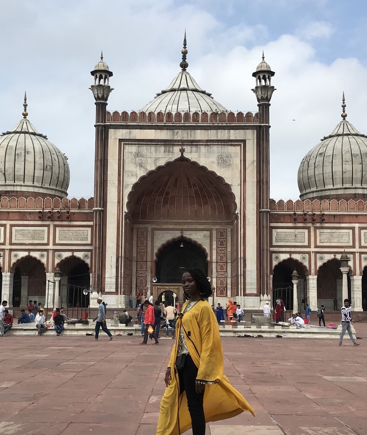 Une foule s'est rassemblée devant une grande structure architecturale avec des dômes.