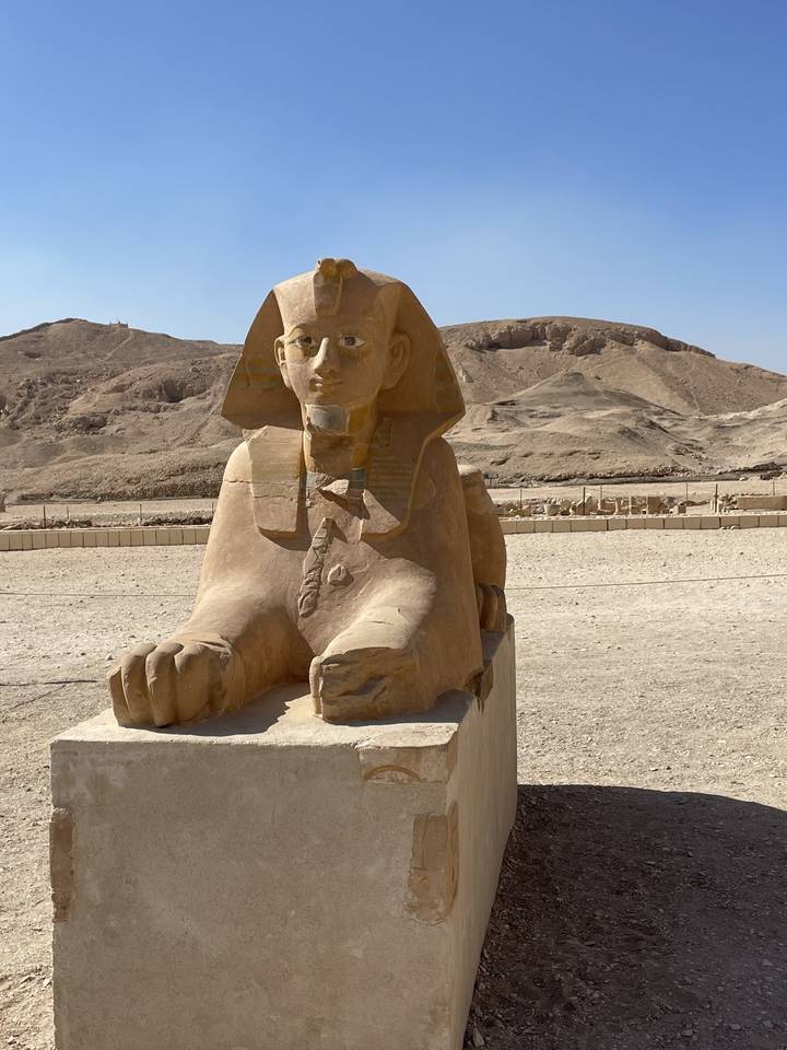 Egyptian Sphinx statue in a desert landscape.