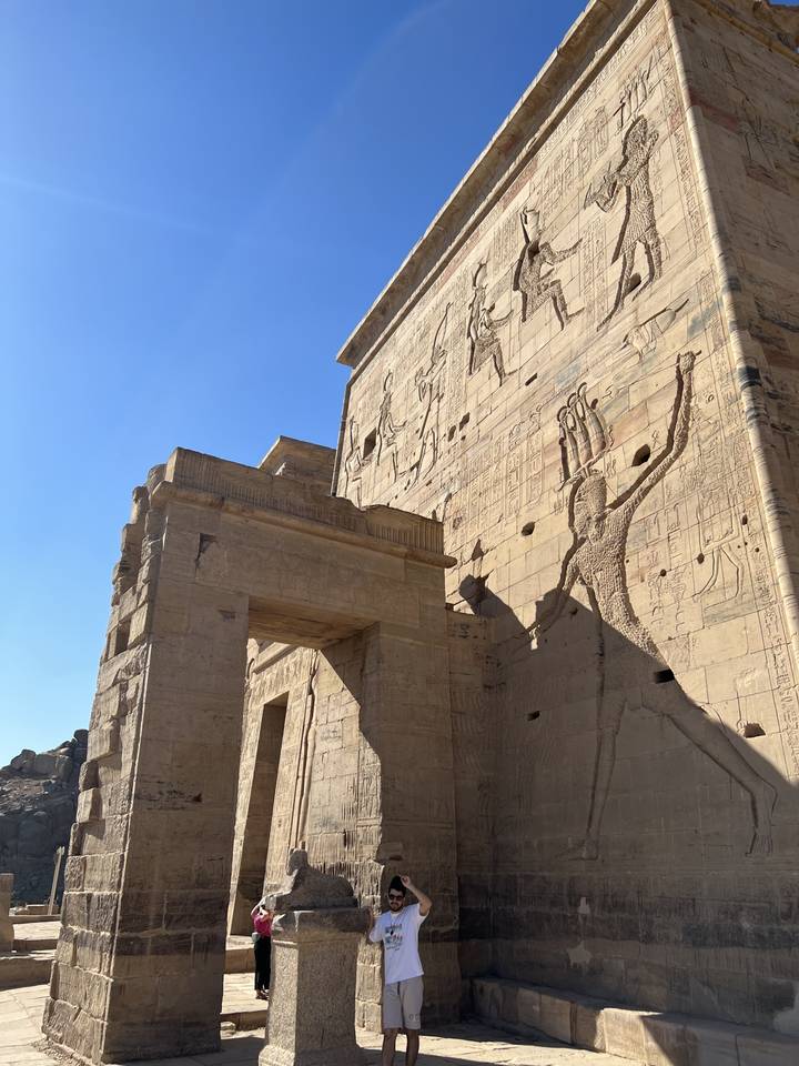 People photographing large ancient ruins with carvings.