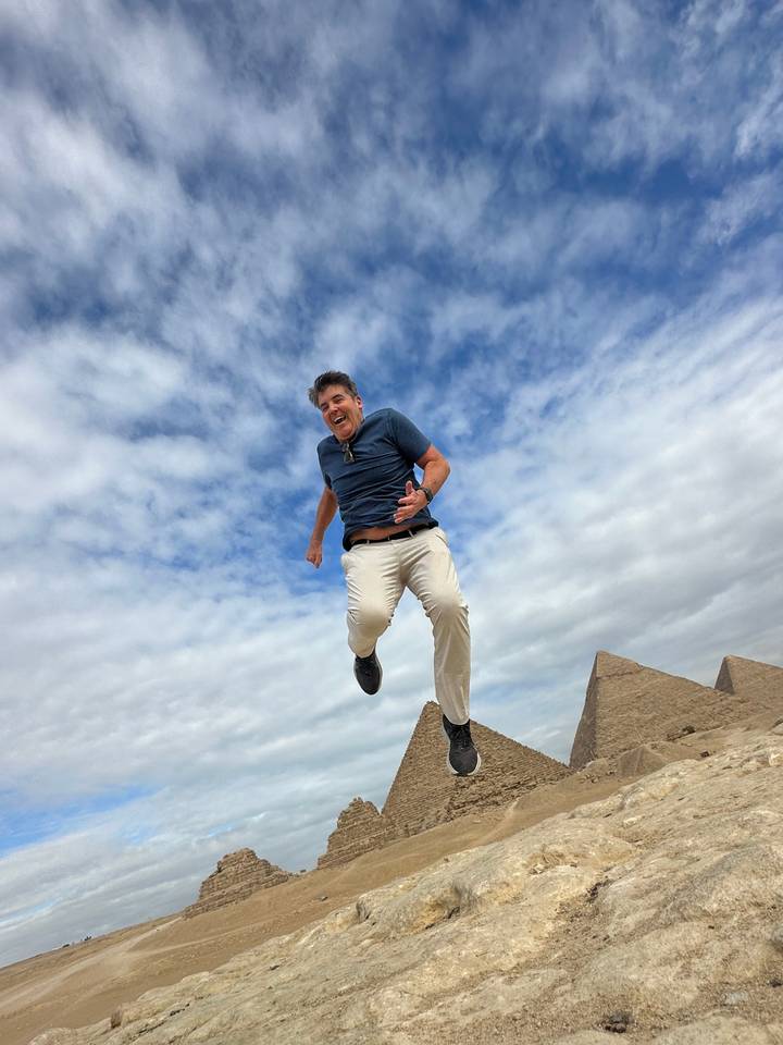 Personne posant avec les pyramides égyptiennes en arrière-plan.