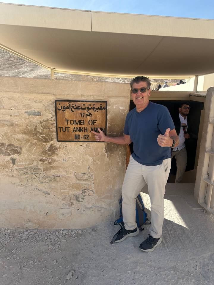 Homme à l'entrée d'une tombe avec signalisation.