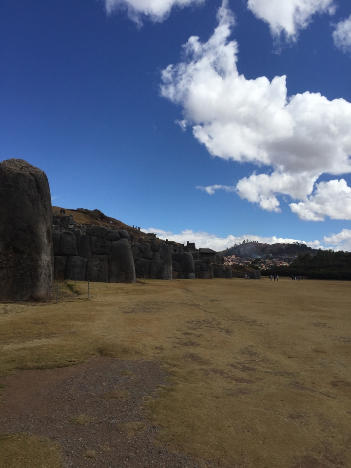 Stone ruins and landscape with mountains in background.
