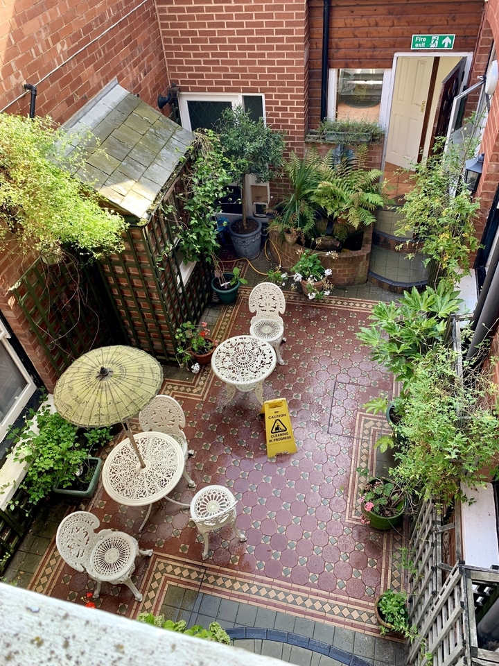 Charmante cour avec plantes et chaises.