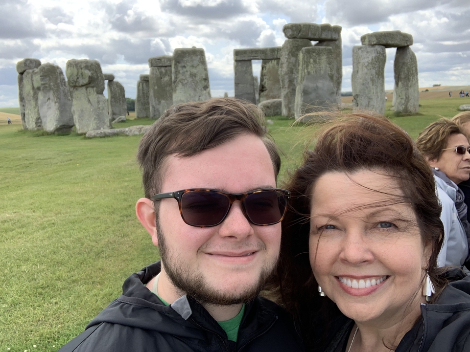 Un couple souriant devant Stonehenge.