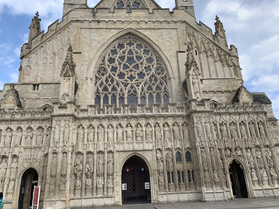 Façade d'une grande cathédrale en pierre avec des sculptures ornementales.