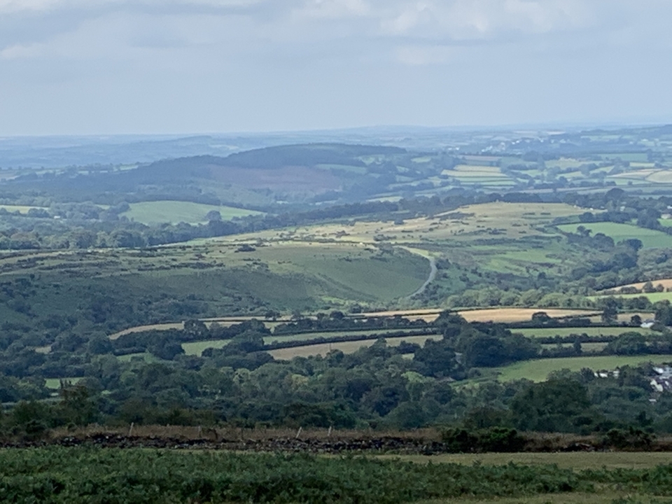 Paysage grand-angle de champs et de collines.