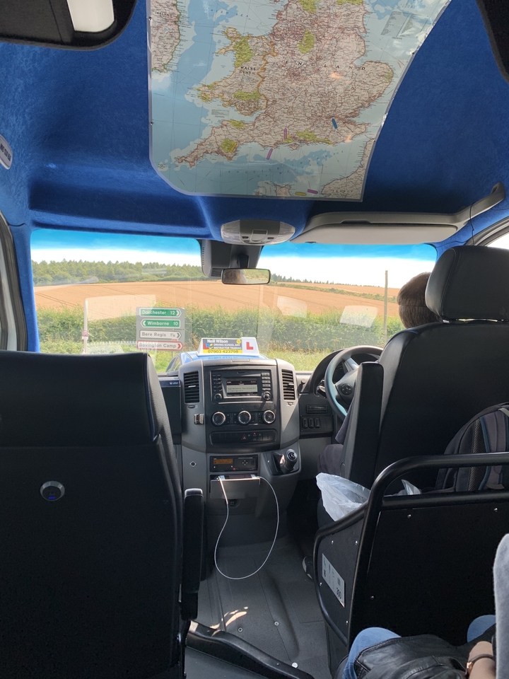 Vue depuis l'intérieur d'un véhicule montrant des panneaux de signalisation et la campagne.
