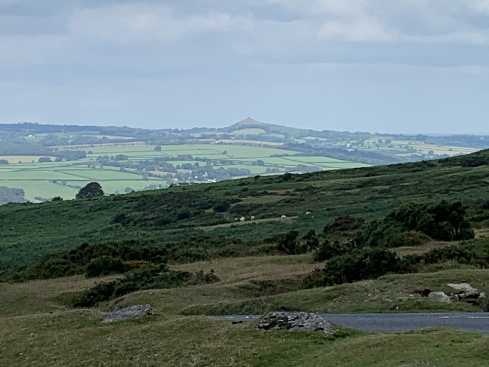 Vue panoramique de la campagne avec des collines au loin.
