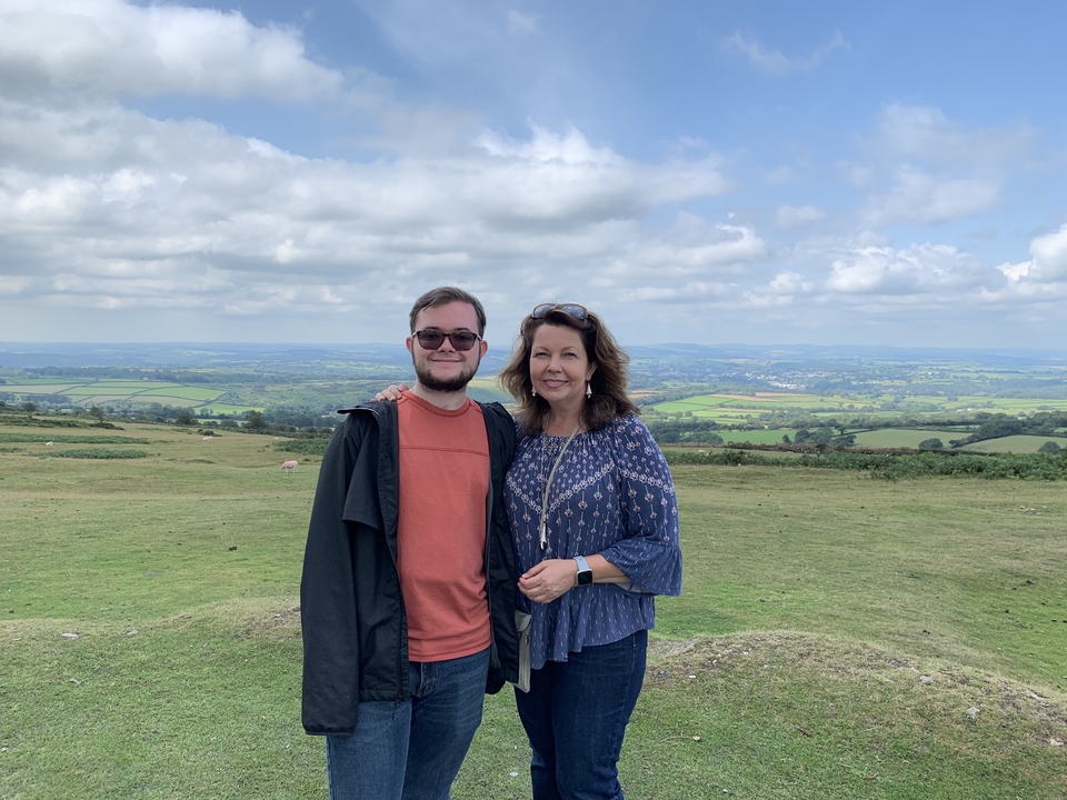 Couple posant avec une vue expansive sur la campagne en arrière-plan.