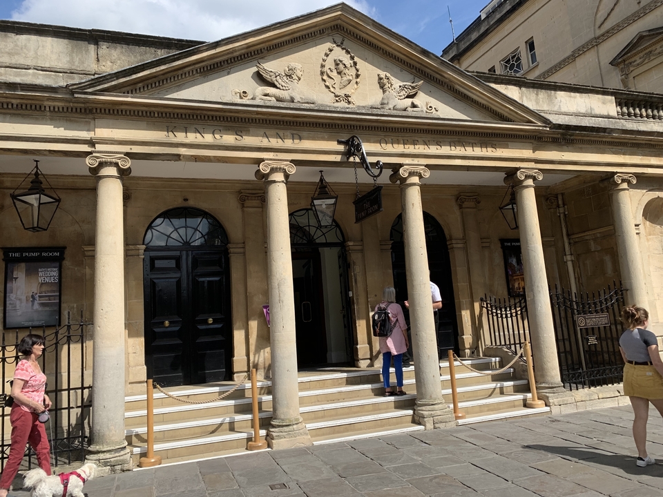 Extérieur de bains publics historiques avec des gens qui entrent.