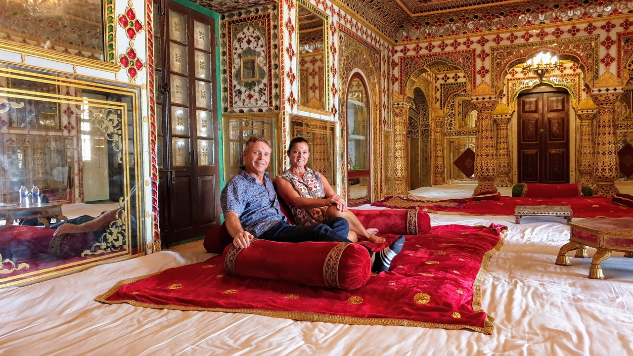 Couple assis dans une pièce luxueuse et richement décorée.