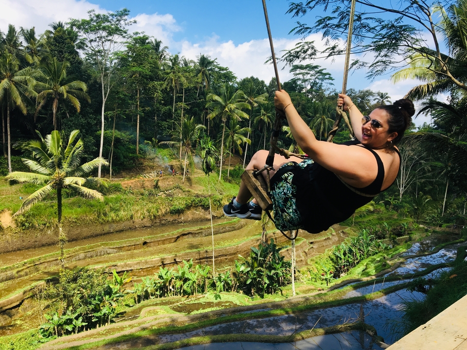 Woman swinging over terraced fields.