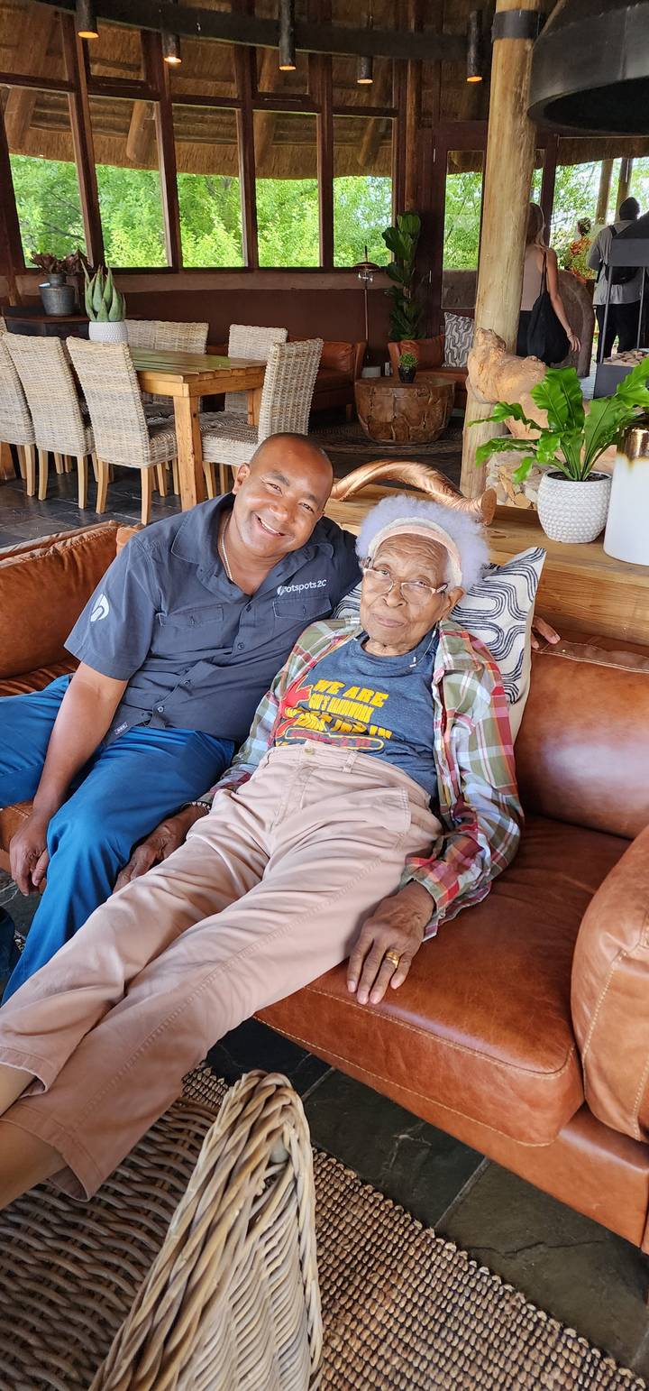 Deux personnes assises sur un canapé dans un cadre rustique.