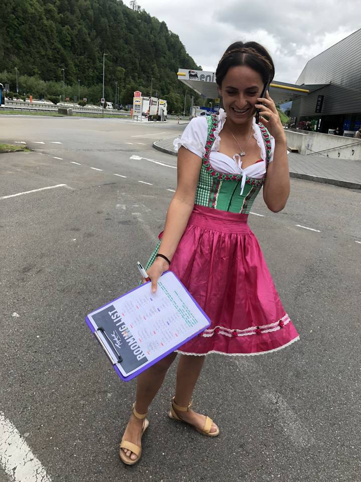 Femme en tenue traditionnelle tenant un presse-papiers dans un parking.