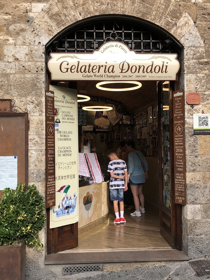 Des gens regardent dans une gelateria avec diverses récompenses.