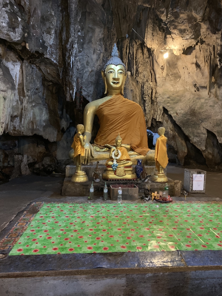 Golden Buddha statues in a cave setting.