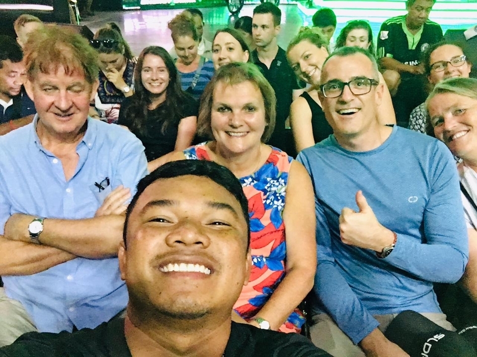 Groupe de personnes souriantes dans une salle bondée.