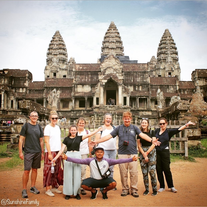 Groupe de touristes posant devant Angkor Wat.