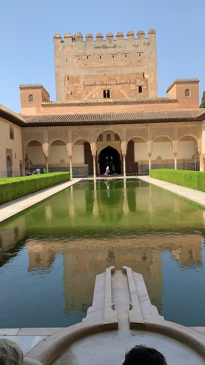 Moorish architecture with a reflecting pool and intricate tile work.