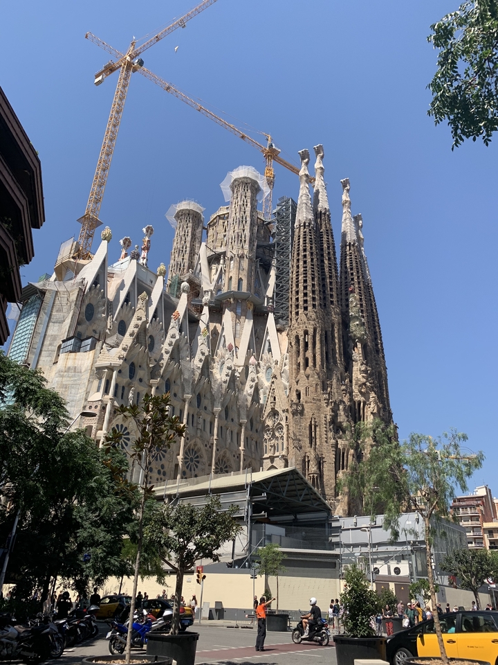 Sagrada Familia with intricate gothic architecture under bright blue sky.