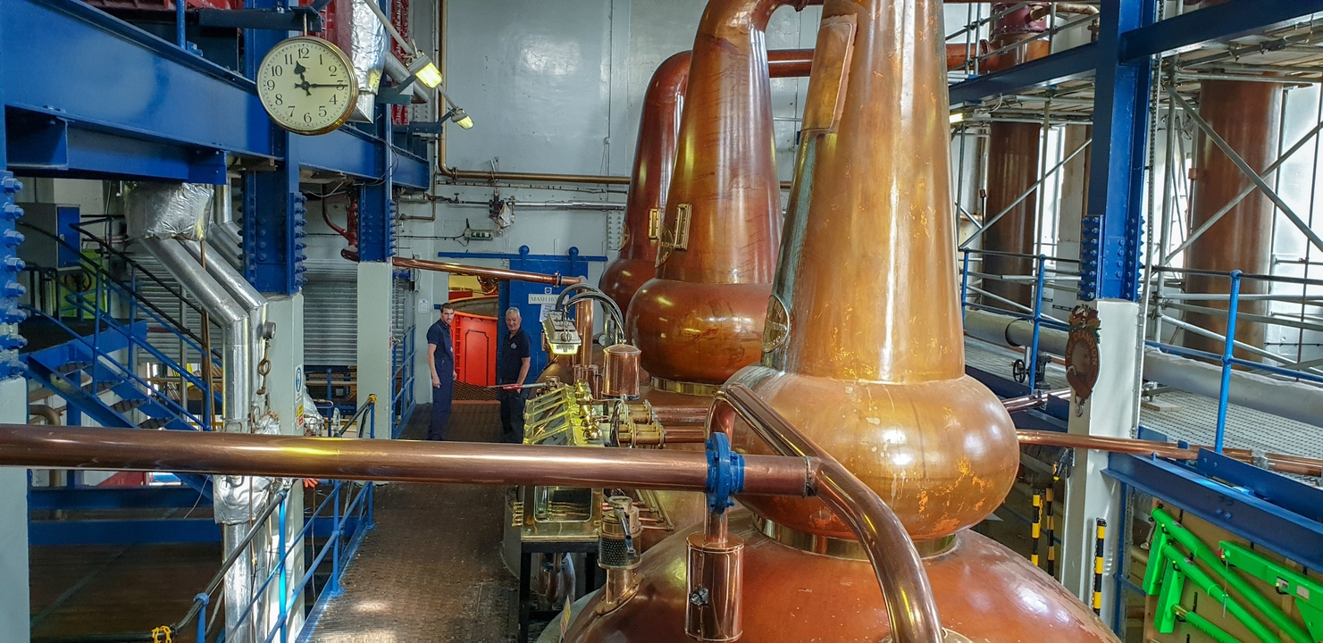 Intérieur d'une distillerie avec des alambics en cuivre.