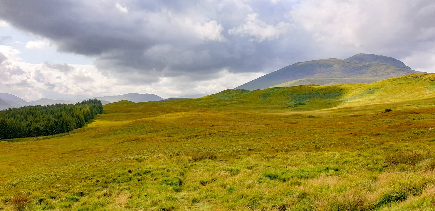 A scenic landscape with hills and clouds.