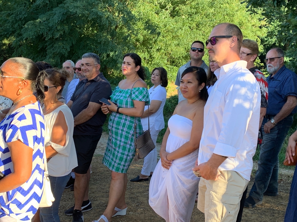 Groupe de personnes lors d'un événement en plein air au coucher du soleil.
