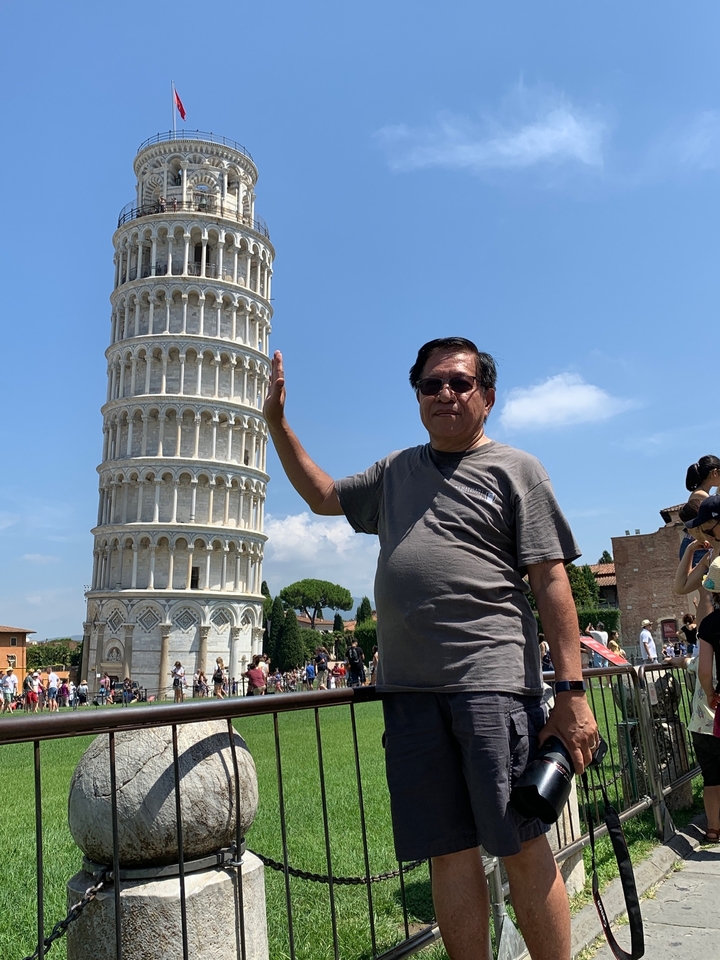 Personne posant comme si elle soutenait la tour penchée de Pise.