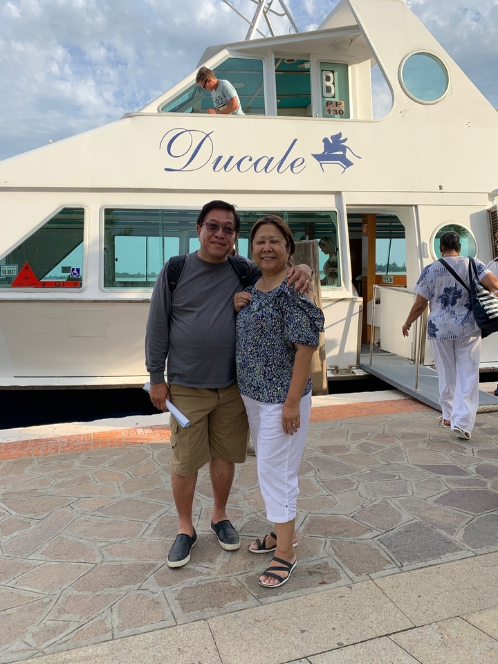 Deux personnes debout devant un bateau.