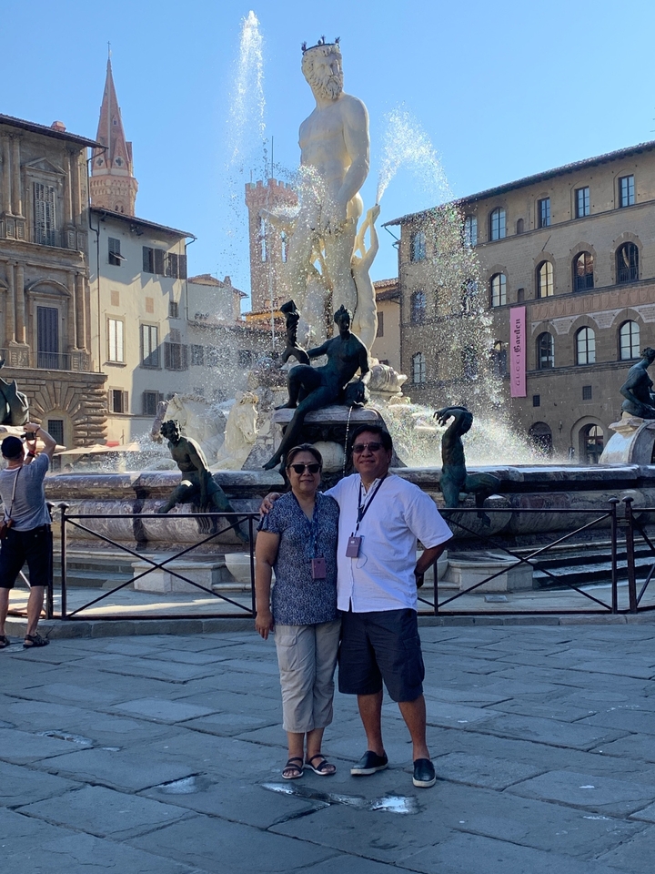Couple posant devant une statue de fontaine.