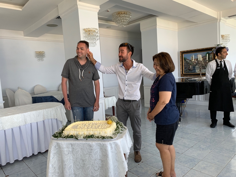 Trois personnes debout autour d'un gâteau décoré à l'intérieur.