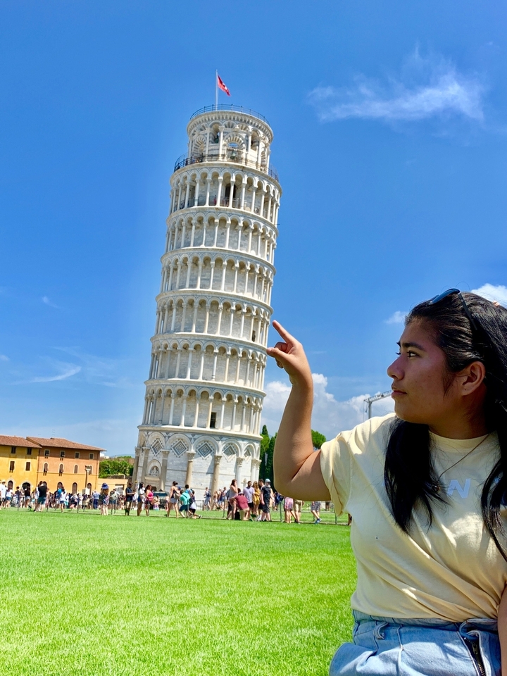 Une personne interagissant de manière ludique avec la Tour de Pise.