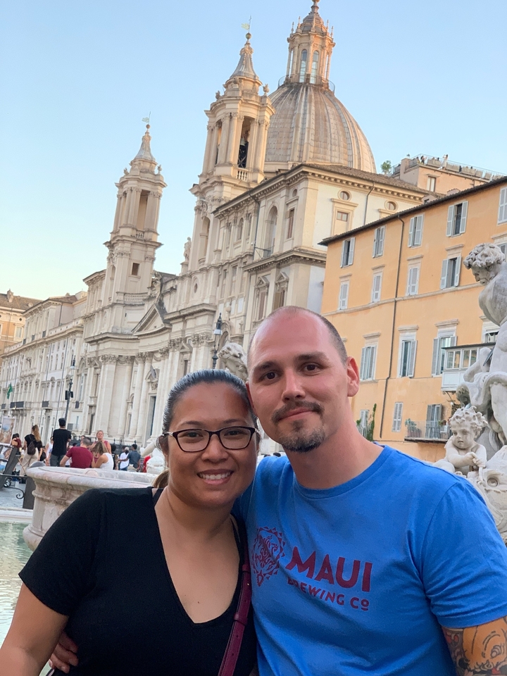 Couple posant devant un bâtiment historique.