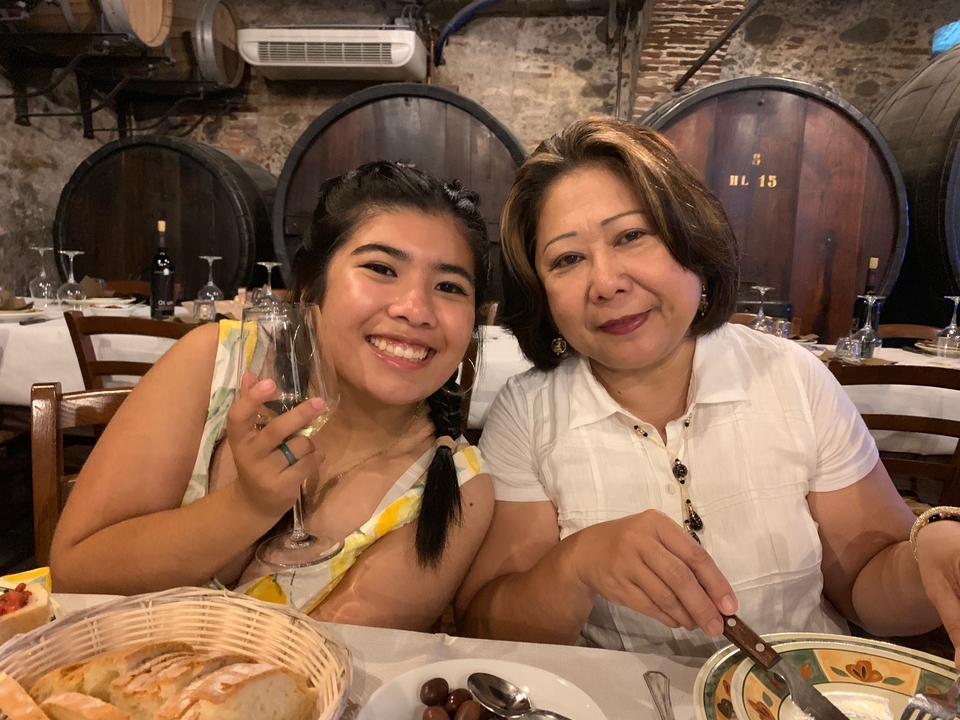 Deux personnes dînant dans un restaurant avec des verres de vin à la main.