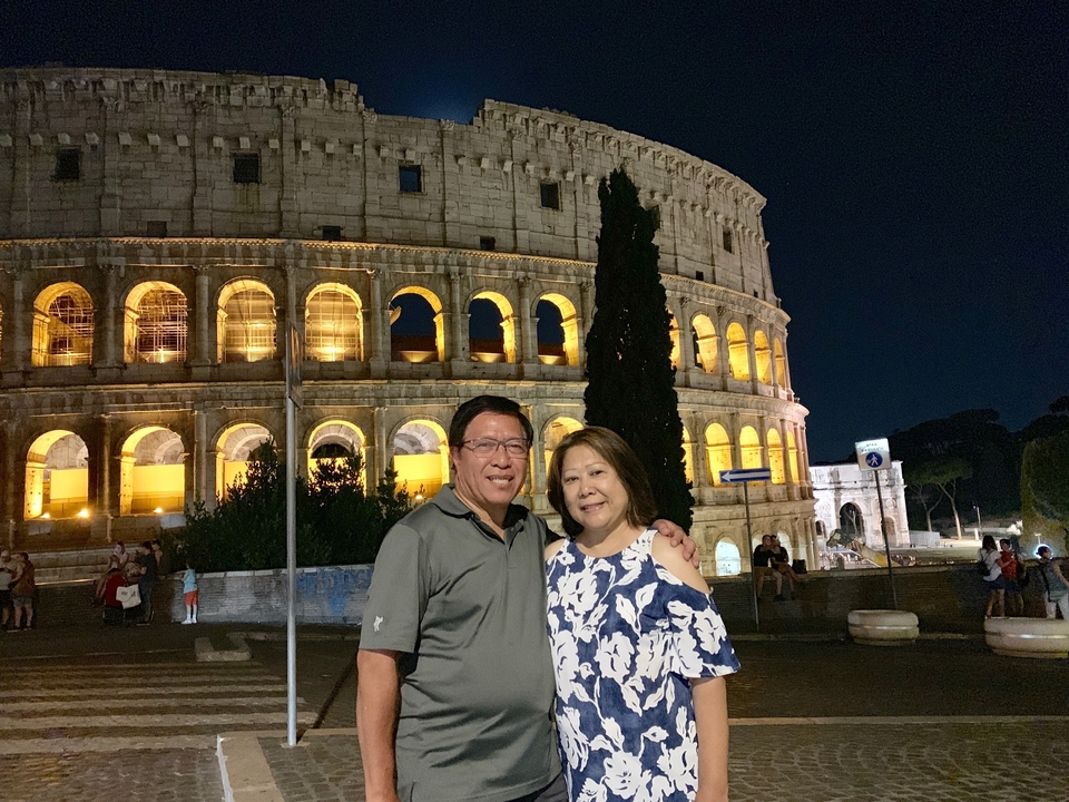 Couple posant devant le Colisée la nuit.