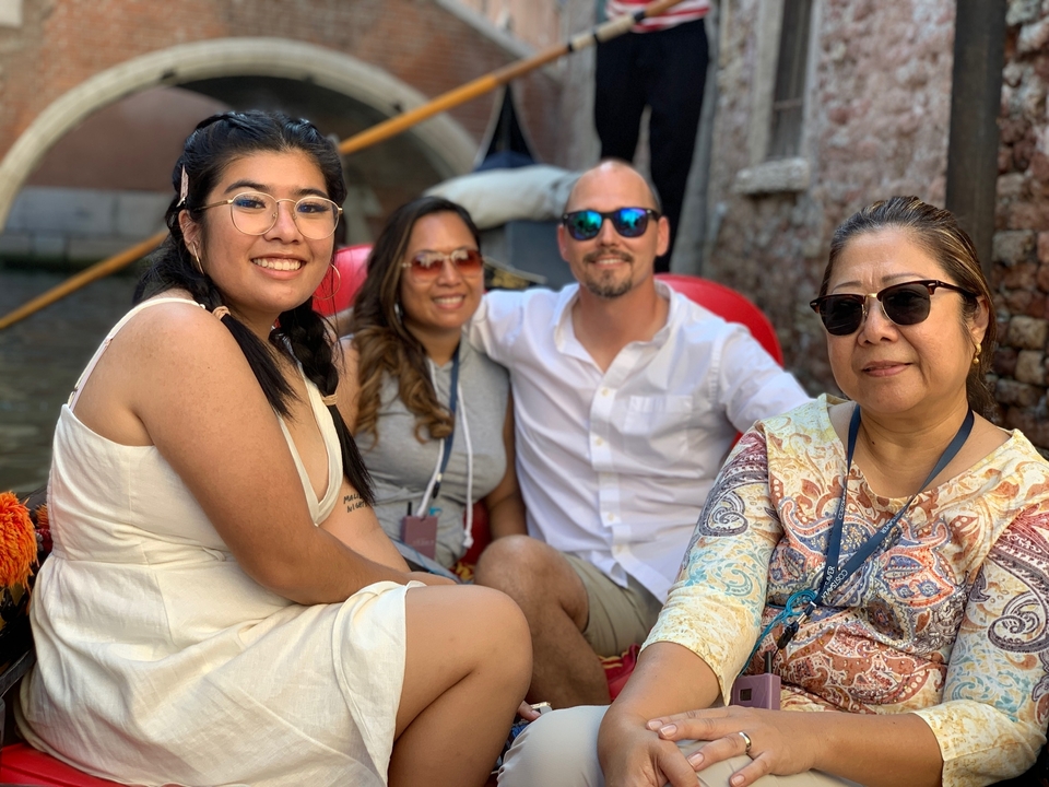 Groupe de quatre personnes assises dans une gondole sur un canal.
