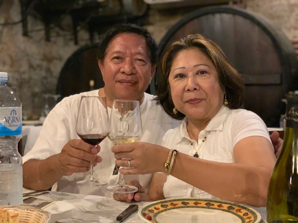 Couple trinquant avec des verres de vin.