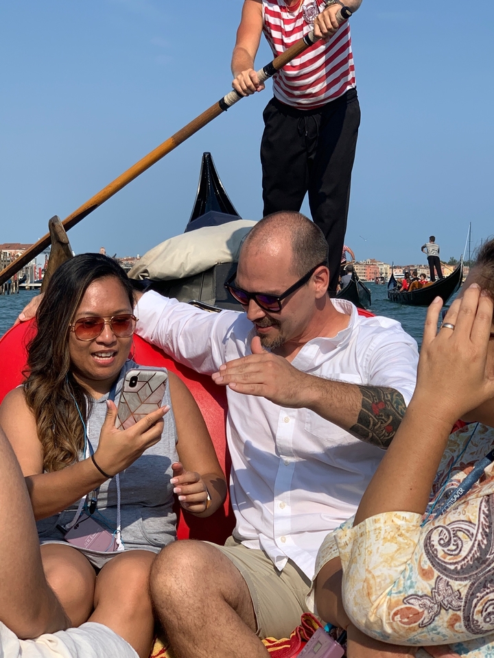 Deux personnes sur un bateau dans un canal, regardant un smartphone.