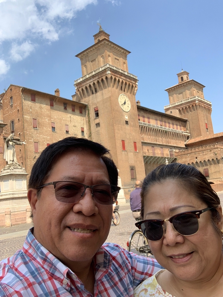 Couple posant devant un château historique.